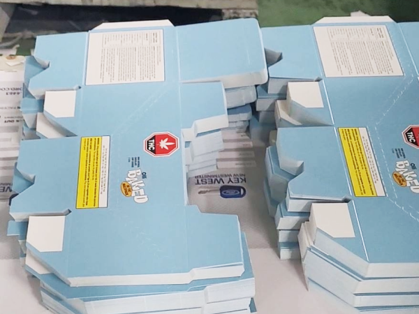 Stacked and cut sheets of Olli's Cannabis Product Boxes